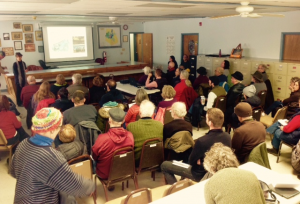 Image of many people viewing a presentation