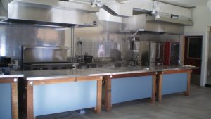 Image of a large commercial kitchen with many cooking stations