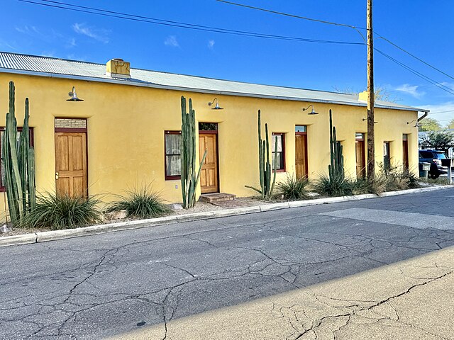 Single story yellow building with tin roof, wood doors and cacti on 17th st in Barriro Viejo, photo curtesy of Share Alike 2.0